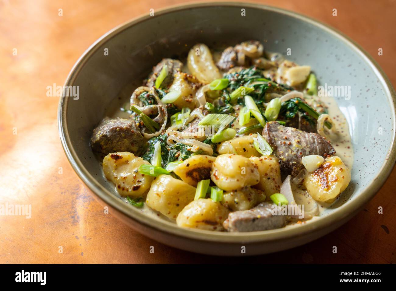 Gnocchi with steak and broccolini and green onions Stock Photo