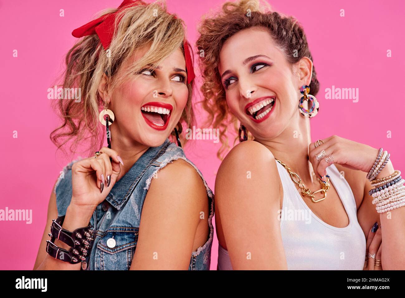 We share a love for 80s fashion. Studio shot of two beautiful young women  styled in 80s clothing Stock Photo - Alamy