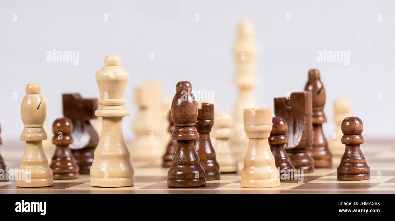 Chess pieces on a chess board during a game with a light background Stock Photo