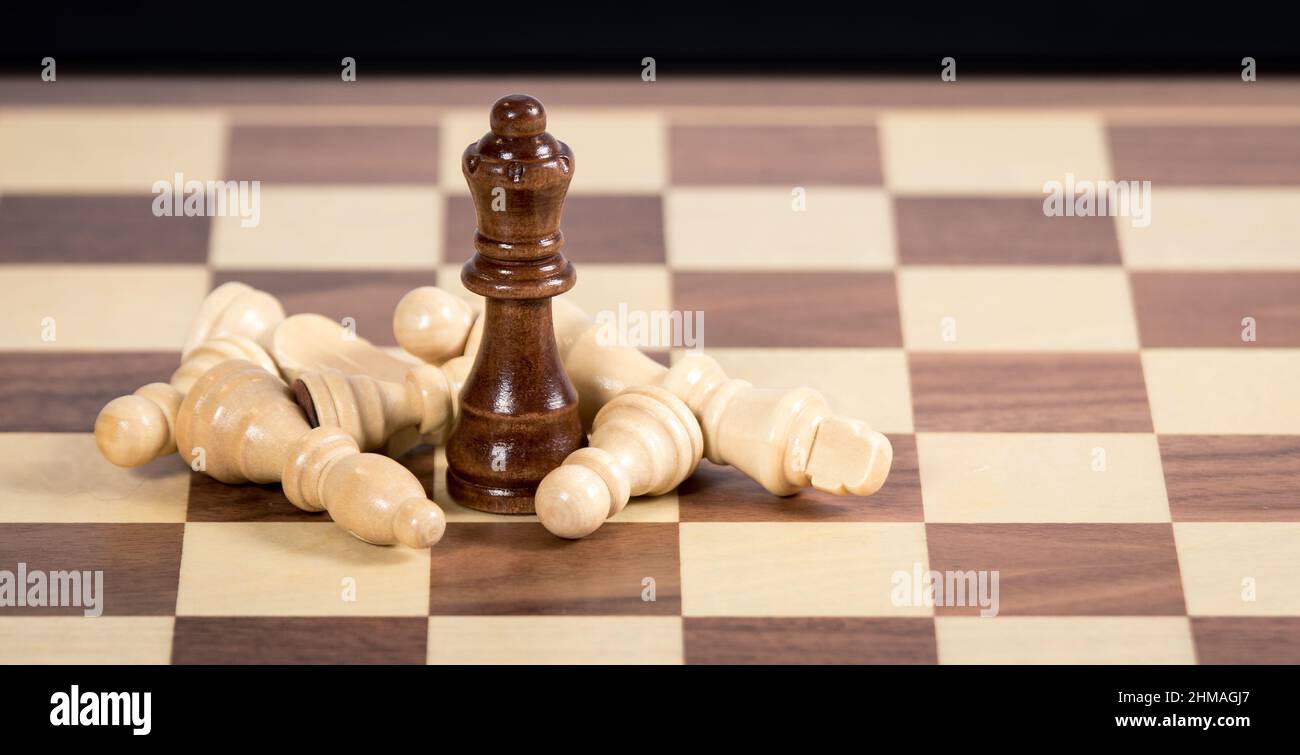 Fallen Chess pieces lying around a queen piece Stock Photo