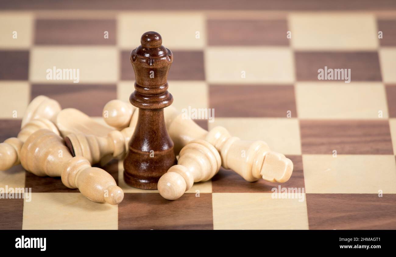 Fallen Chess pieces lying around a queen piece Stock Photo
