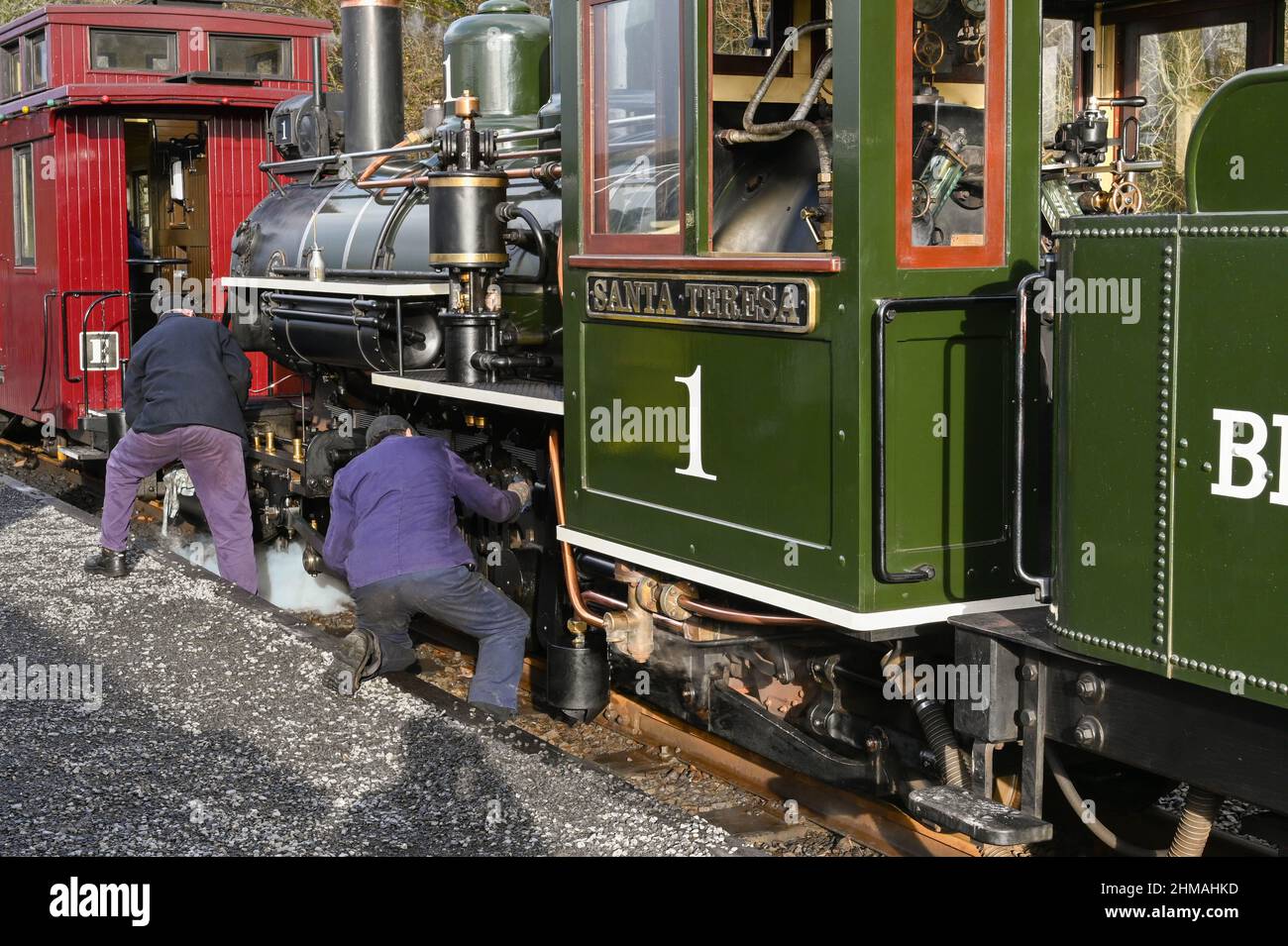 Merthyr Tydfil, Wales - December 2021: Train crew oiling wheels on a vintage steam engine on the narrow gauge railway of the Brecon Mountain Railway Stock Photo