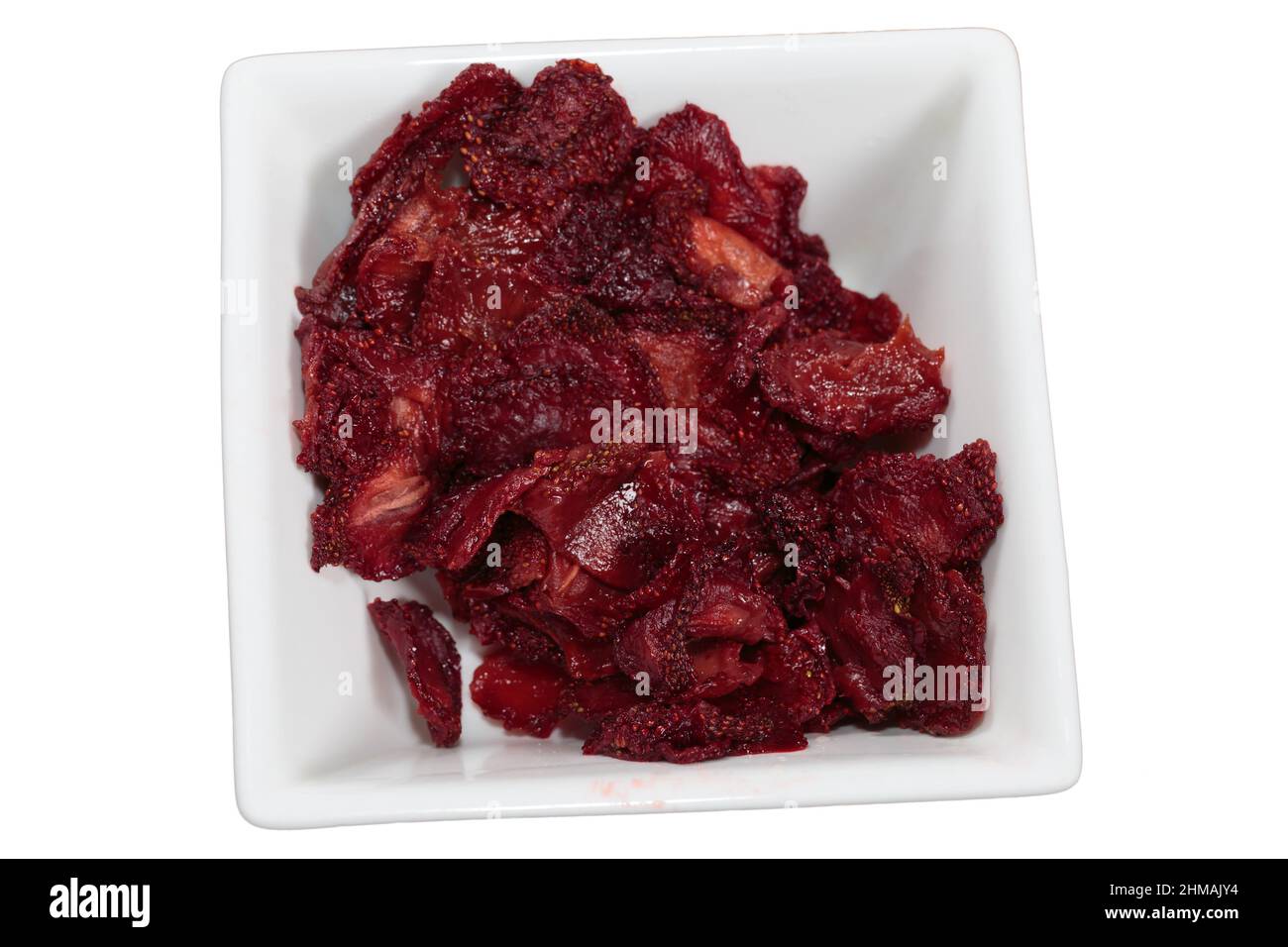 Heap of dried strawberries in white squaer bowl. It isolated over white background. Close-up. Stock Photo
