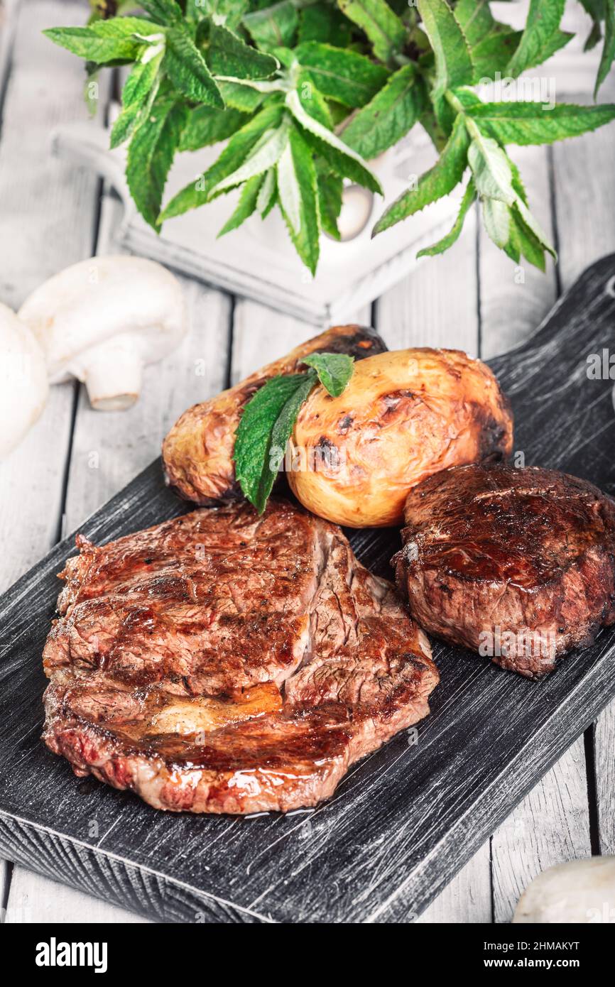 Selection of medium rare steaks, cut with knife with potato wedges as
