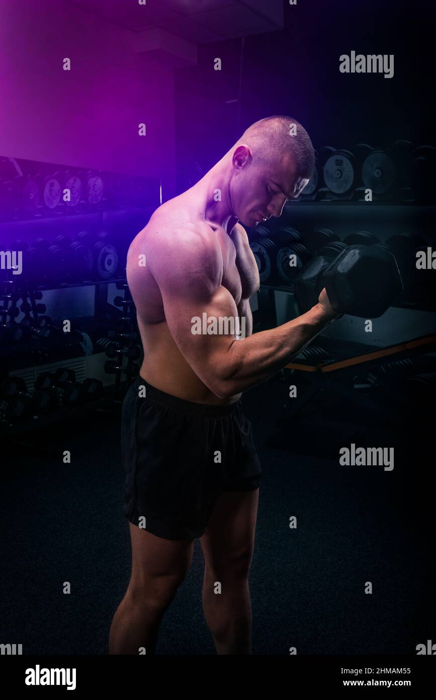 Sportsman lifting heavy dumbbell in a gym Stock Photo Alamy