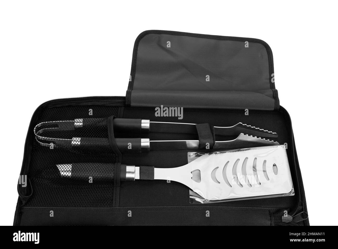 Set of tools for bbq in black bag. It is located on a white surface. Close-up. Stock Photo