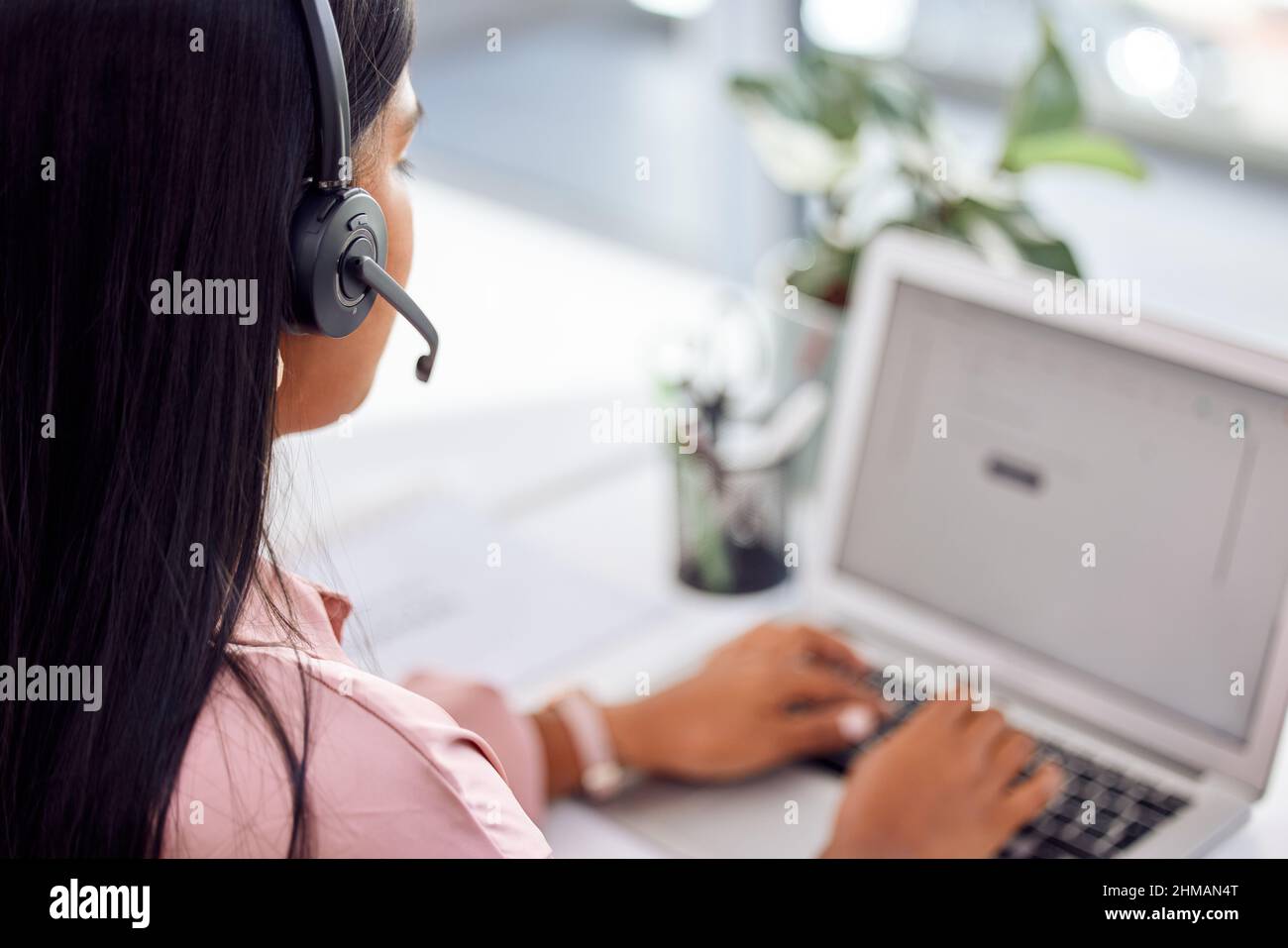 If theres a problem, well a.find a the solution. Shot of a businesswoman wearing a headset while working on her laptop. Stock Photo