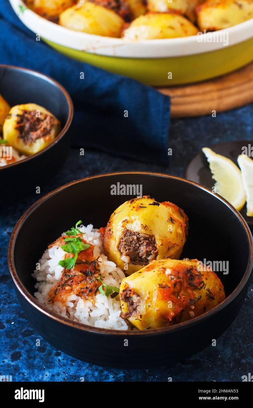 Baked potato stuffed with mince meat and rice with salad. Popular middle eastern food - batata mahshi. Stock Photo