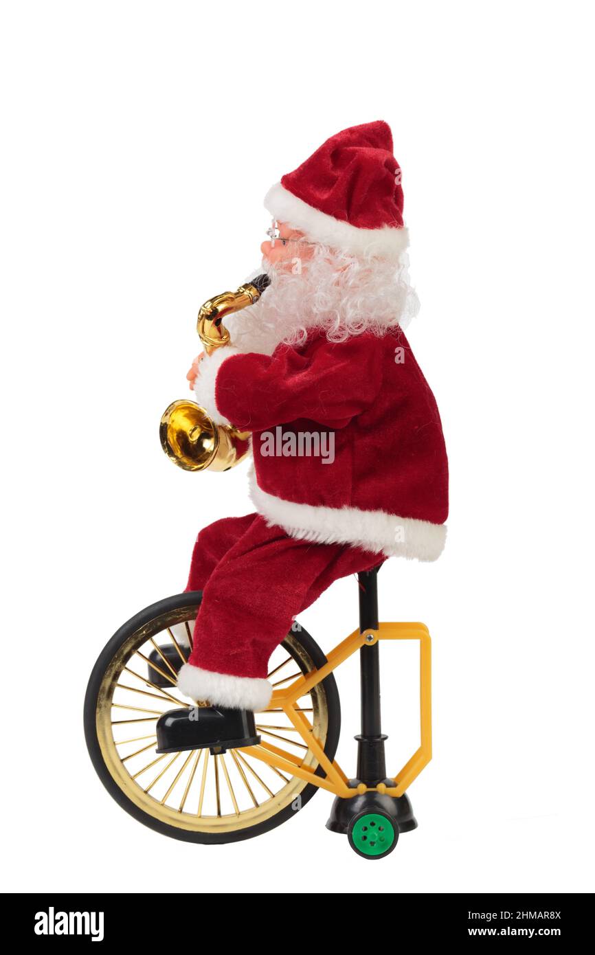 Santa Claus on a bicycle with a saxophone. Isolated over white background. Close-up. Stock Photo