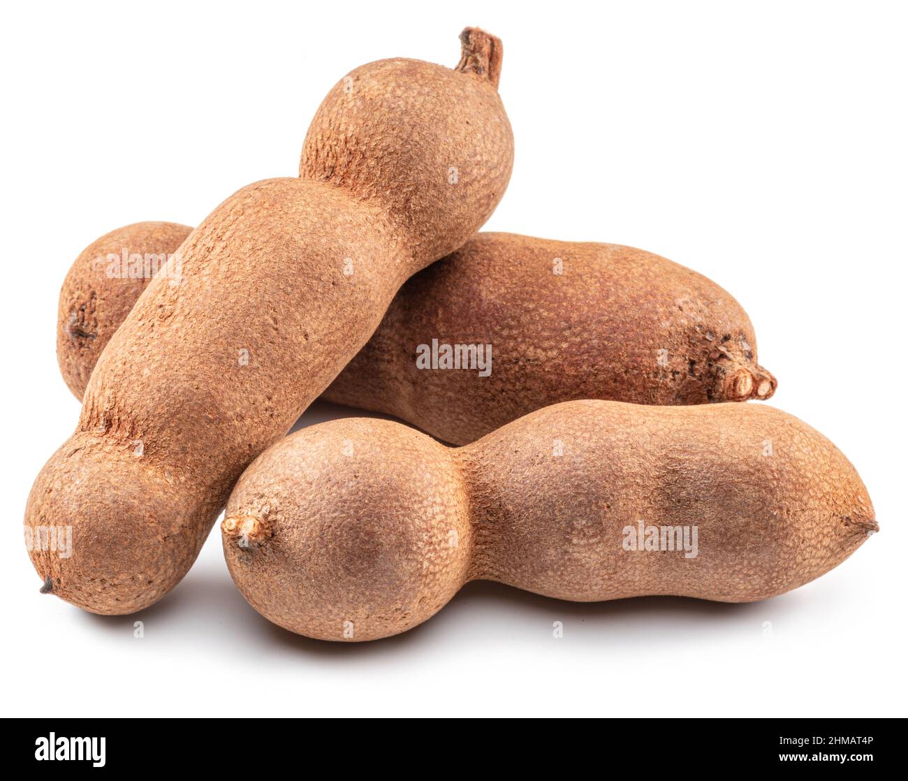 Ripe tamarind fruit pods and leaves isolated on white background Stock