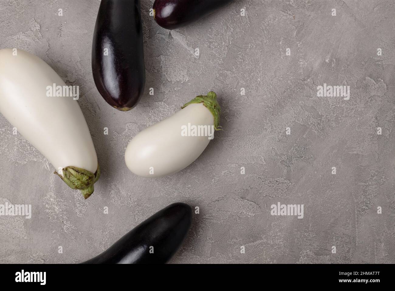 Assorted white and blue fresh raw eggplant pattern on gray on table background. Healthy vegetarian diet food Stock Photo