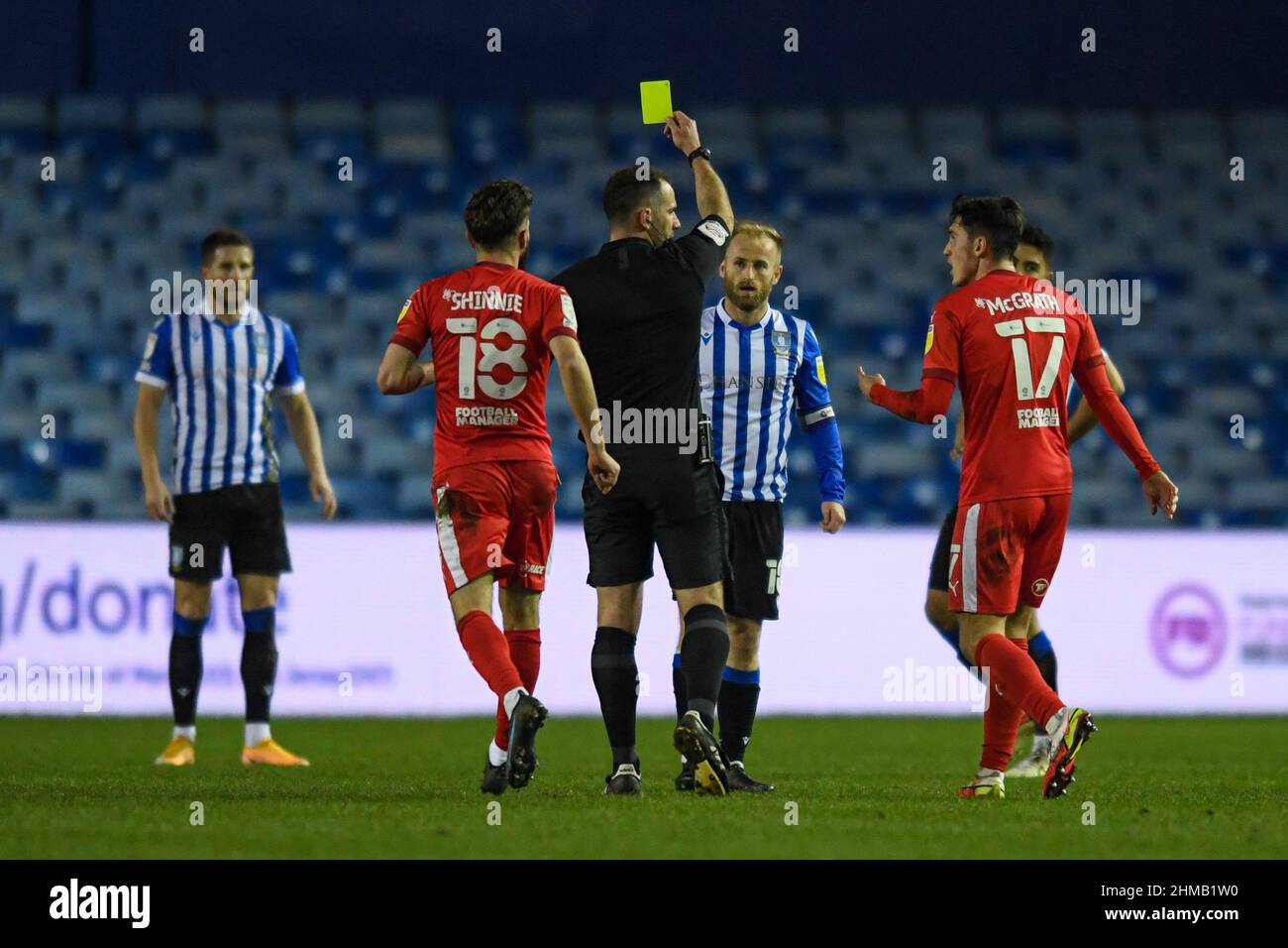 Referee Tim Robinson shows Barry Bannan #10 of Sheffield Wednesday a yellow card Stock Photo