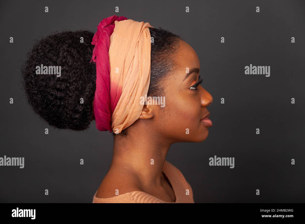 A close up portrait of a black woman with her hair tied back and wearing and hair band. Stock Photo