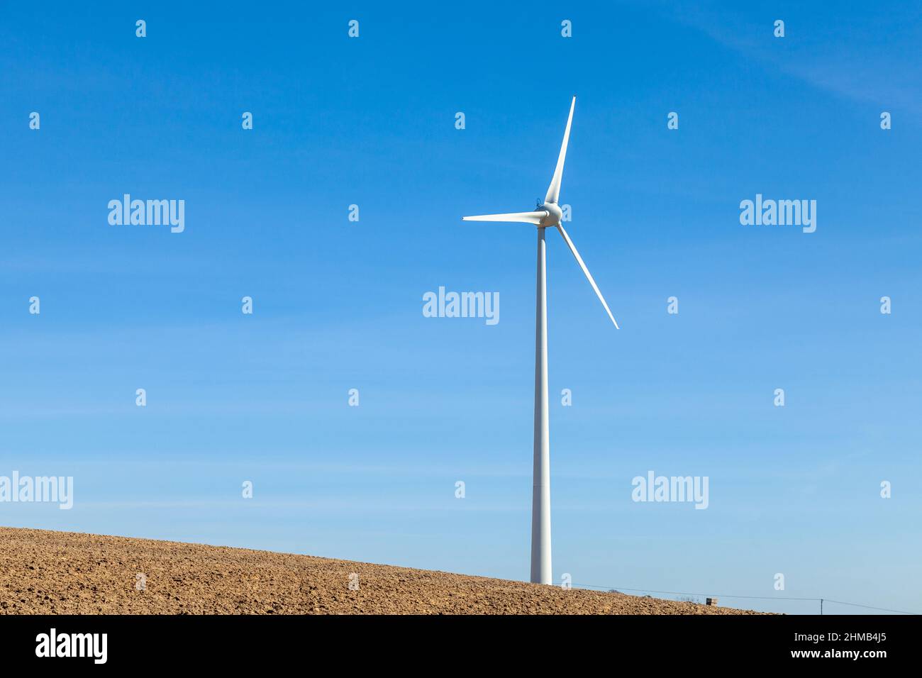 A single wind turbine against a blue sky Stock Photo - Alamy