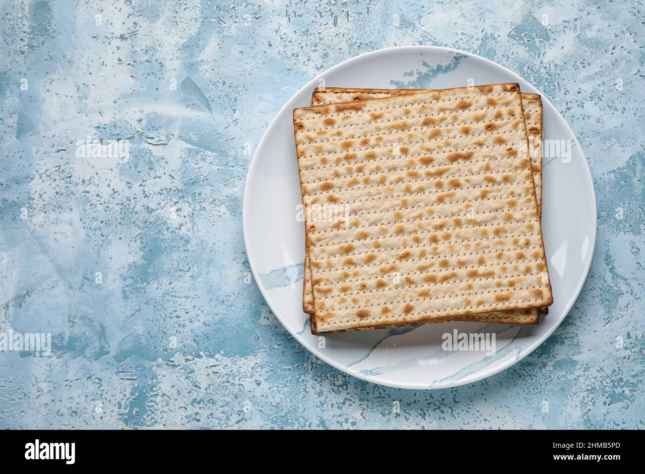Plate with Jewish flatbread for Passover on color background Stock