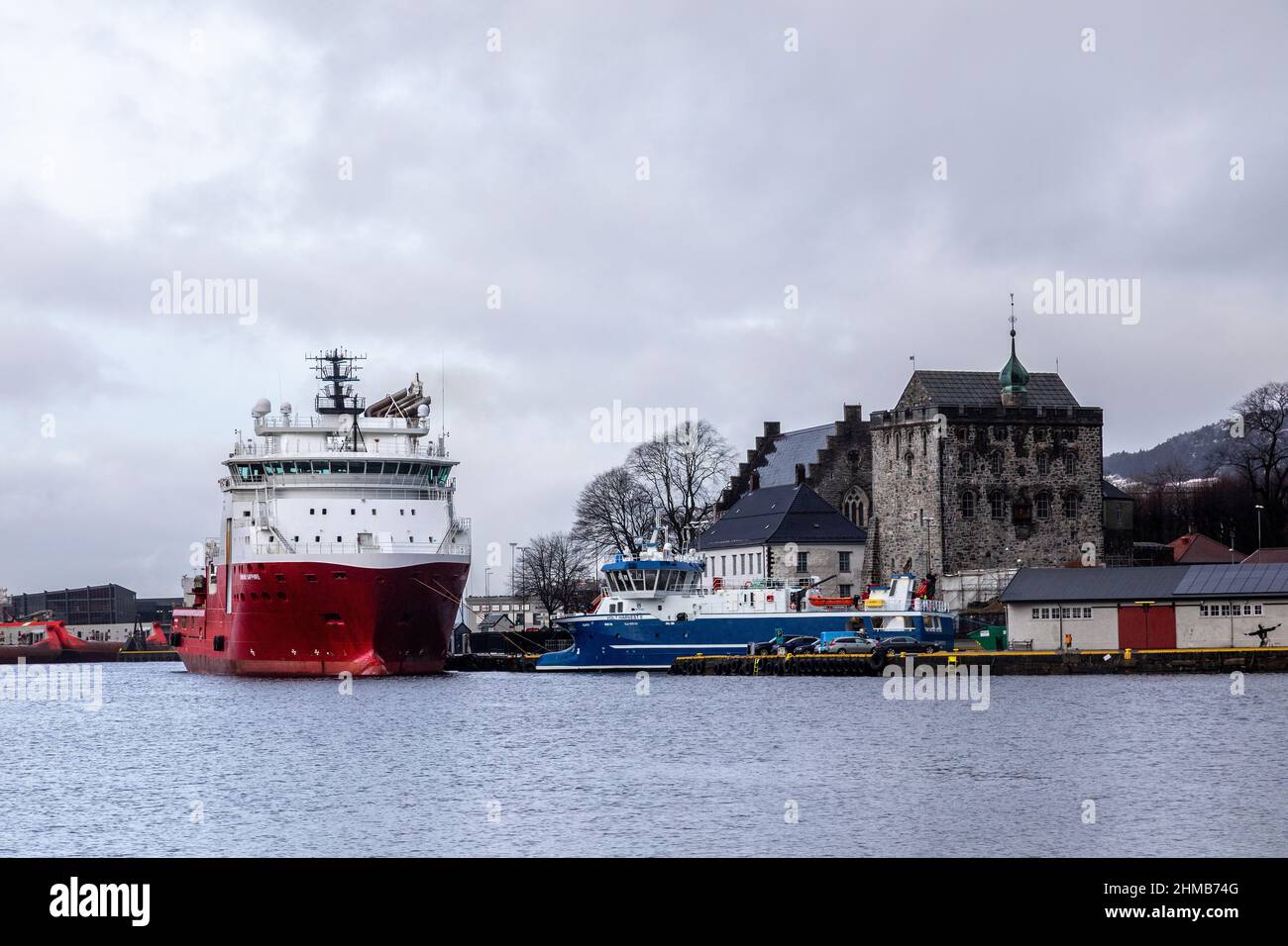Offshore AHTS anchor handling tug supply vessel Normand Sapphire at Festningskaien quay, in port of Bergen, Norway. Fish factory ship Volt Harvest II Stock Photo