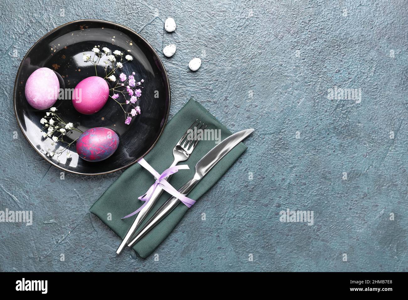 Stylish Easter table setting on dark background Stock Photo