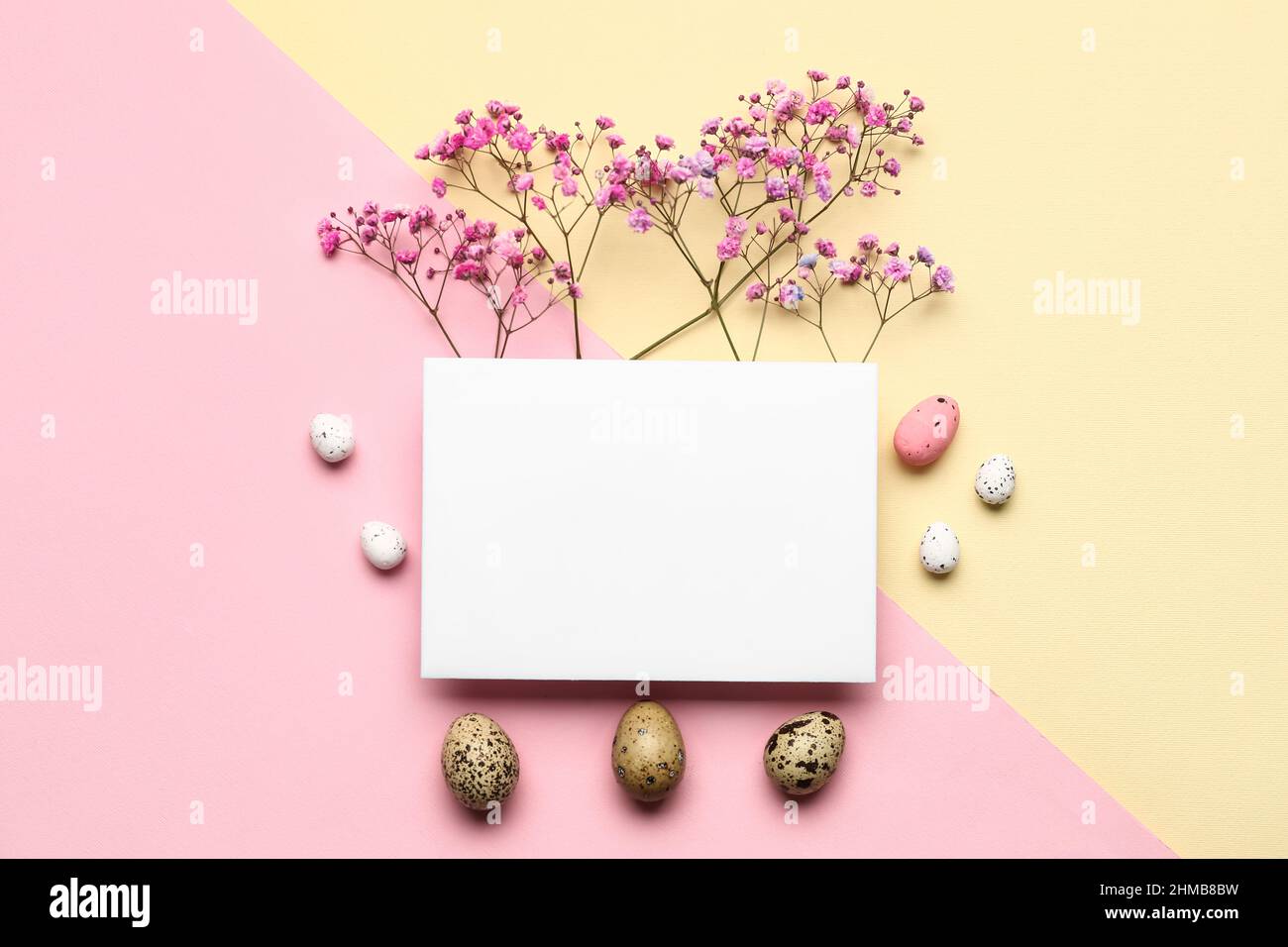 Composition with sheet of paper, Easter eggs and flowers on color ...