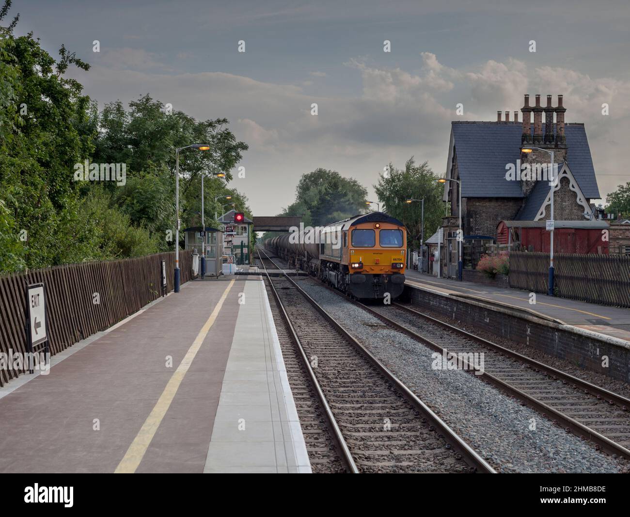 GB Railfreight  Class 66   freight locomotive at Lowdham railway station (East of Nottingham)  with a train of  tanks Stock Photo