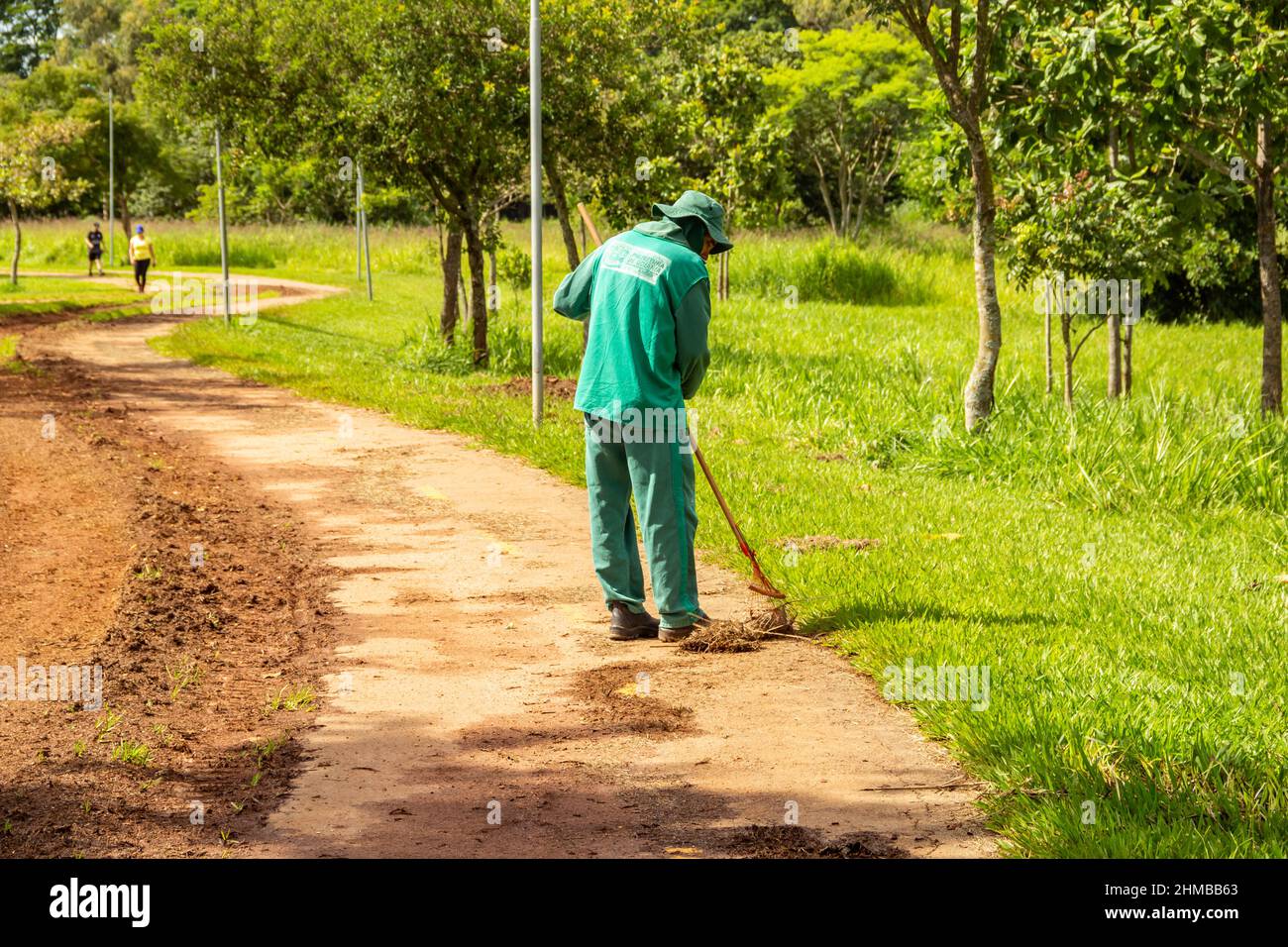 Goiânia, Goias, Brazil – January 18, 2022: A city hall professional doing lawn maintenance in a public park. Stock Photo