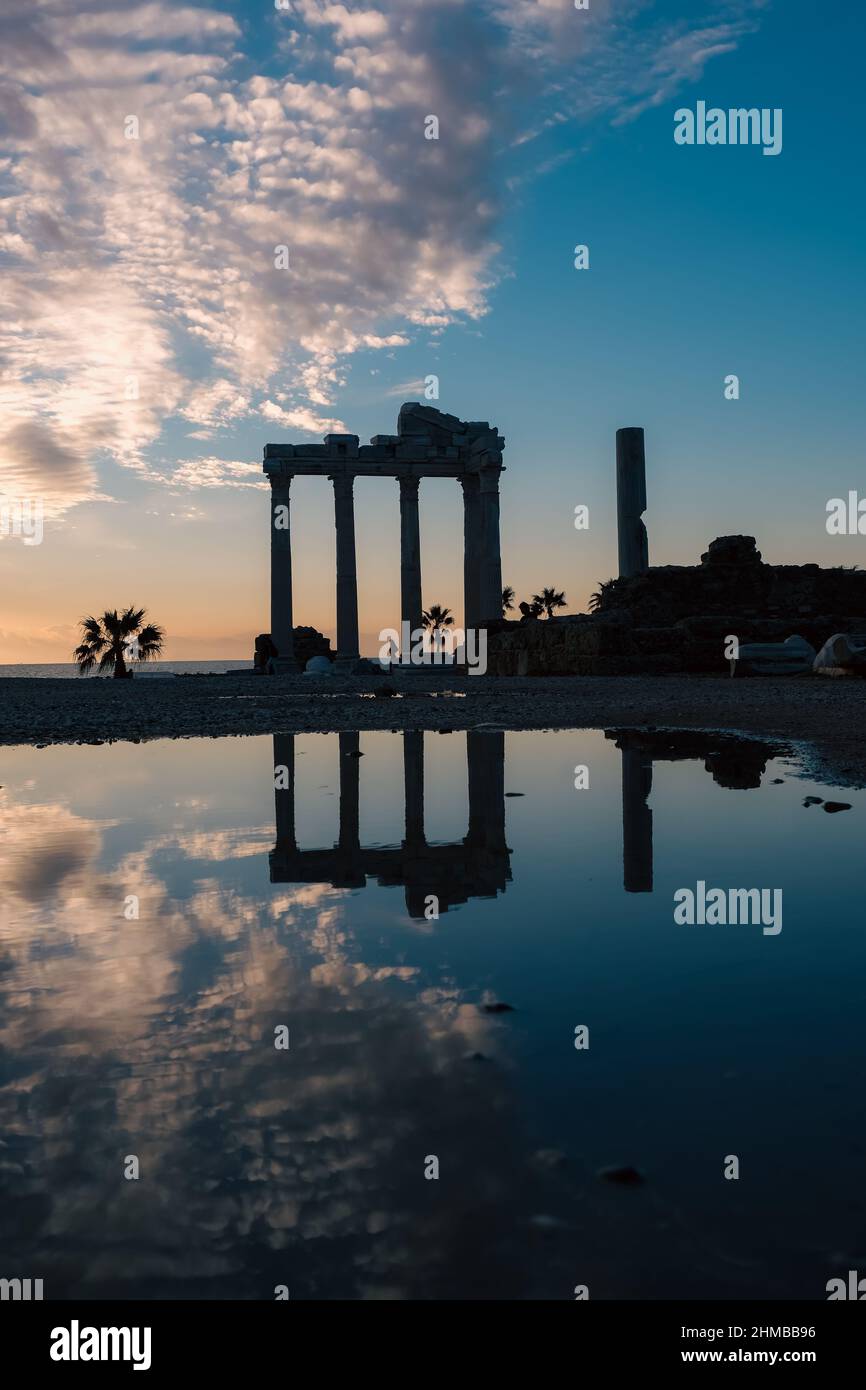 Vertical image of the temple of Apollon ancient ruins at sunset. Silhouette of Apollon Temple in Side antique city, Greek ancient historical antique. Stock Photo