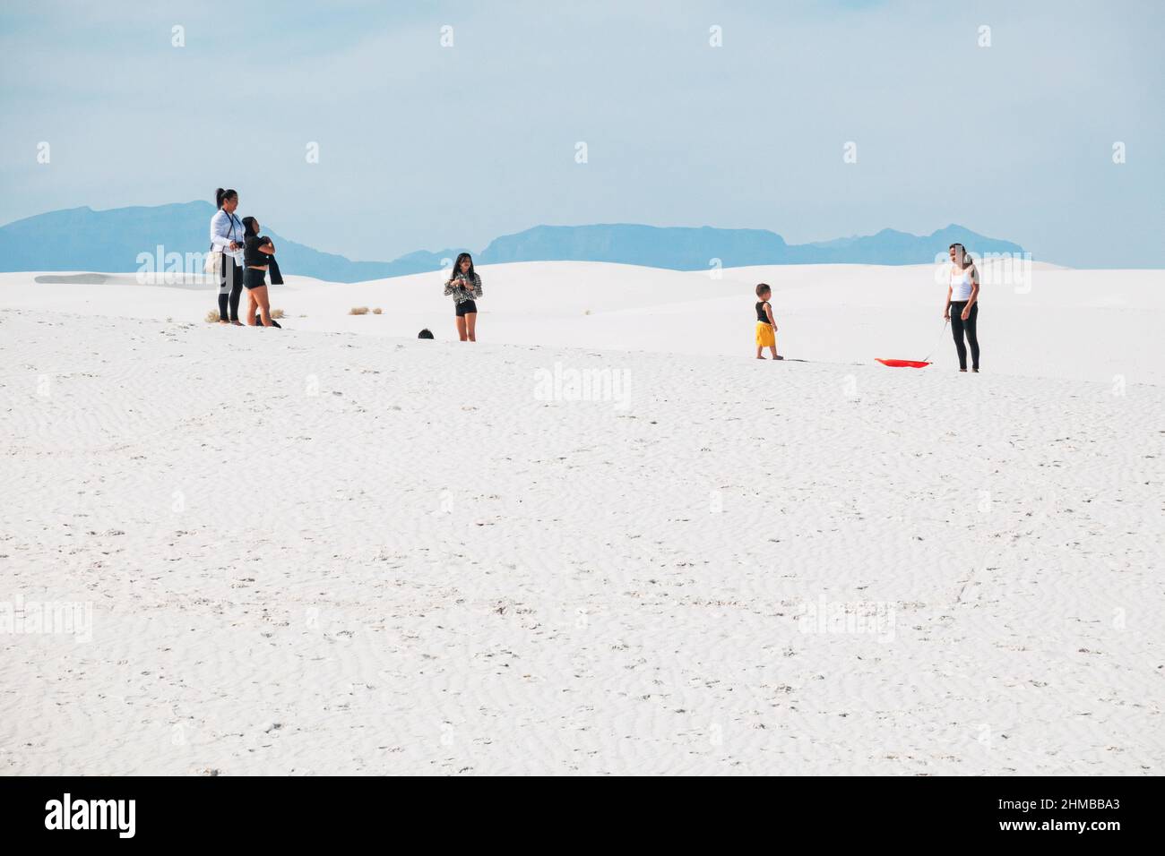 A family plays in the sand dunes at White Sands National Park, New Mexico, United States Stock Photo