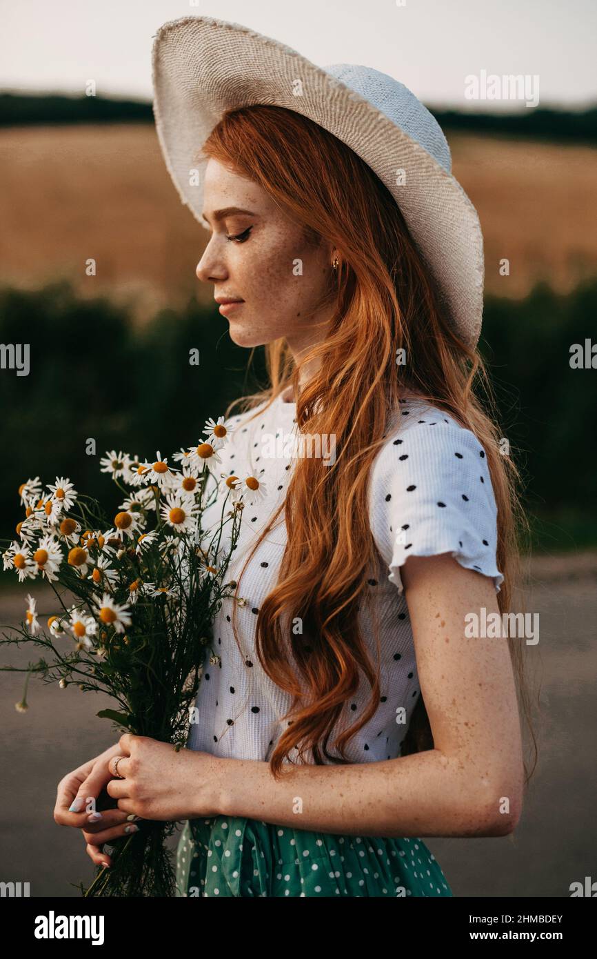 Portrait of a girl holding a bouquet of daisies while walking on a ...