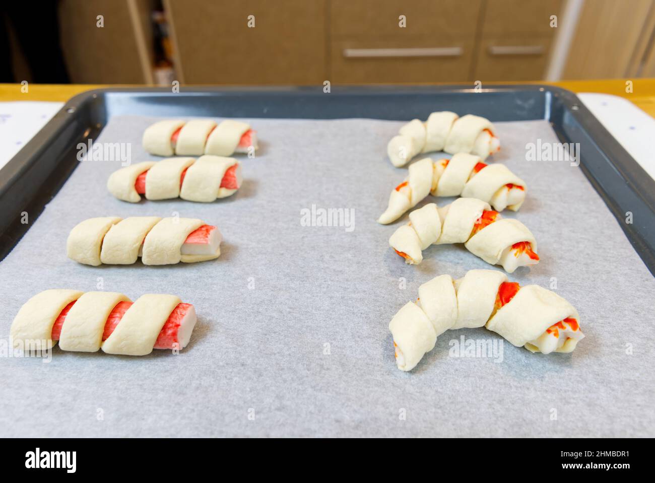 Surimi Crab sticks in puff pastry cooking process. Stock Photo