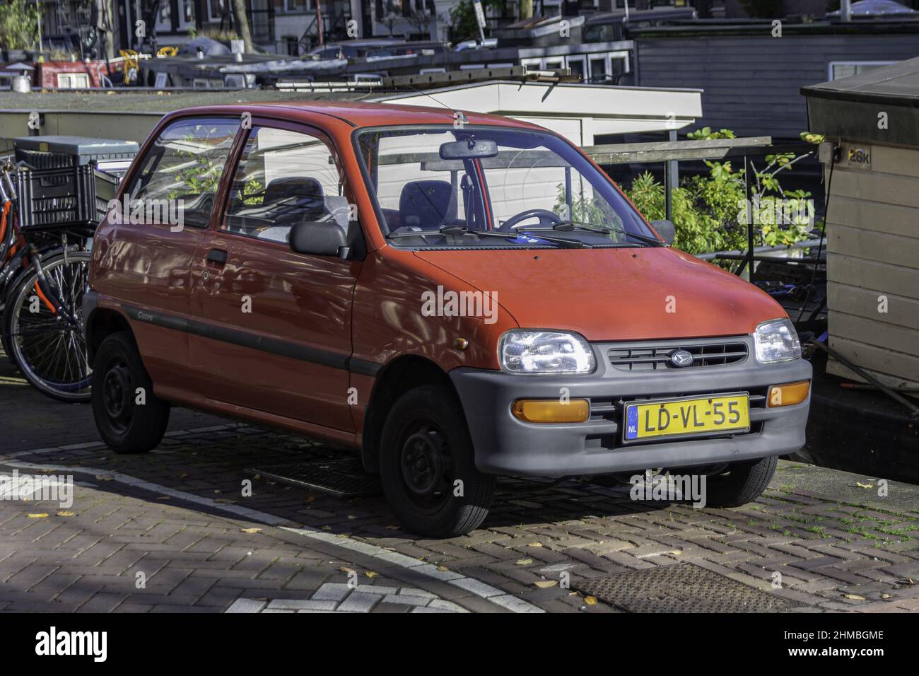 Red Daihatsu Cuore kei car parked in the street Stock Photo