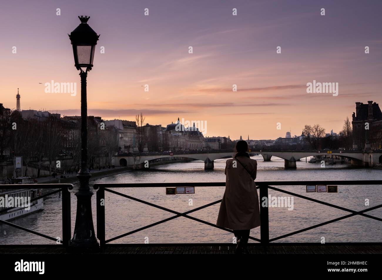 Woman admiring the cityscape of Paris at sunset Stock Photo