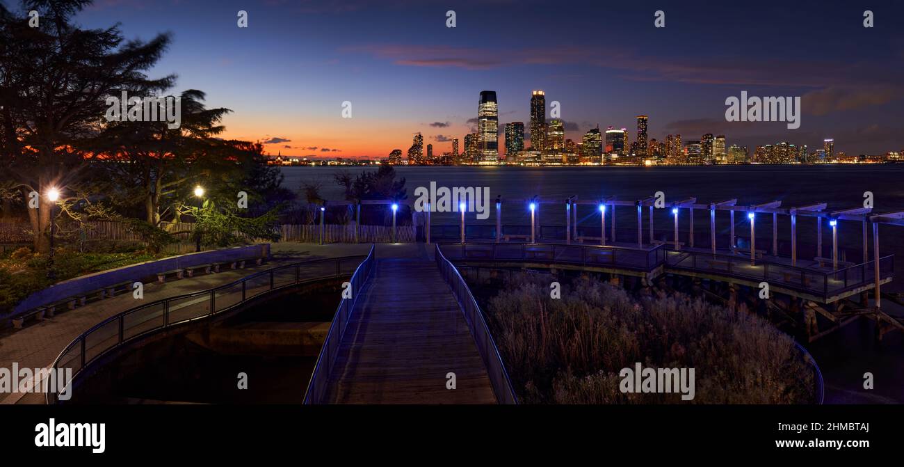 Panoramic evening view of Downtown Jersey City skyscrapers from Battery Park. Riverfront views at twilight from Lower Manhattan, New York City Stock Photo