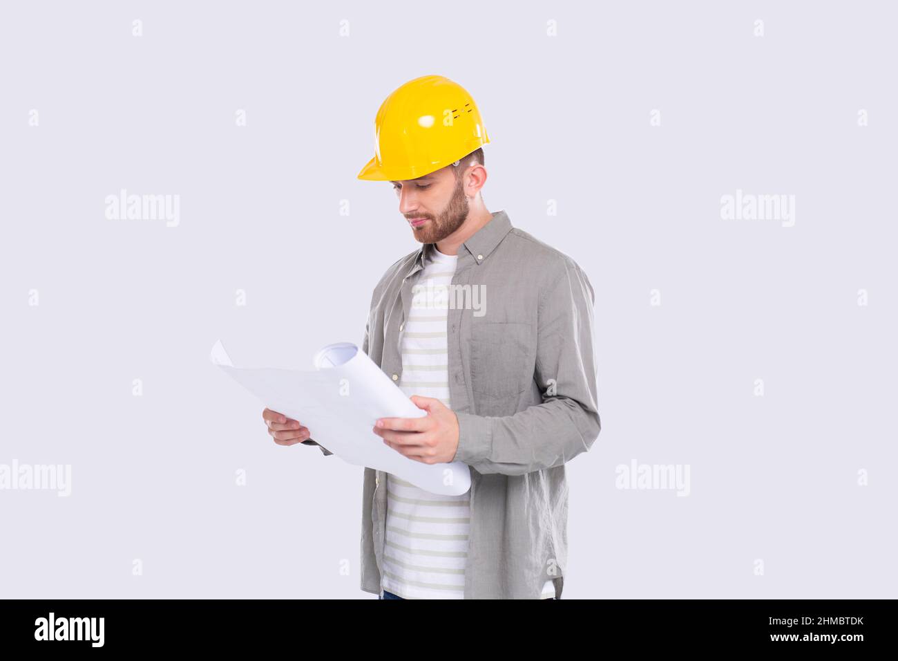 Construction Worker Looking at House Plan. Architect Holding Blueprints. Yellow Hard Helmet. Worker Stock Photo