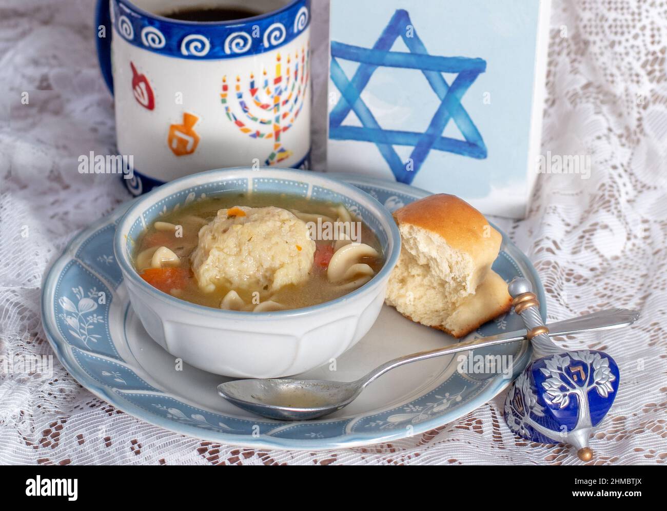 https://c8.alamy.com/comp/2HMBTJX/a-special-hanukkah-still-life-showcases-chicken-p-with-a-matzo-ball-a-special-mug-with-a-menorah-and-a-dreidel-2HMBTJX.jpg