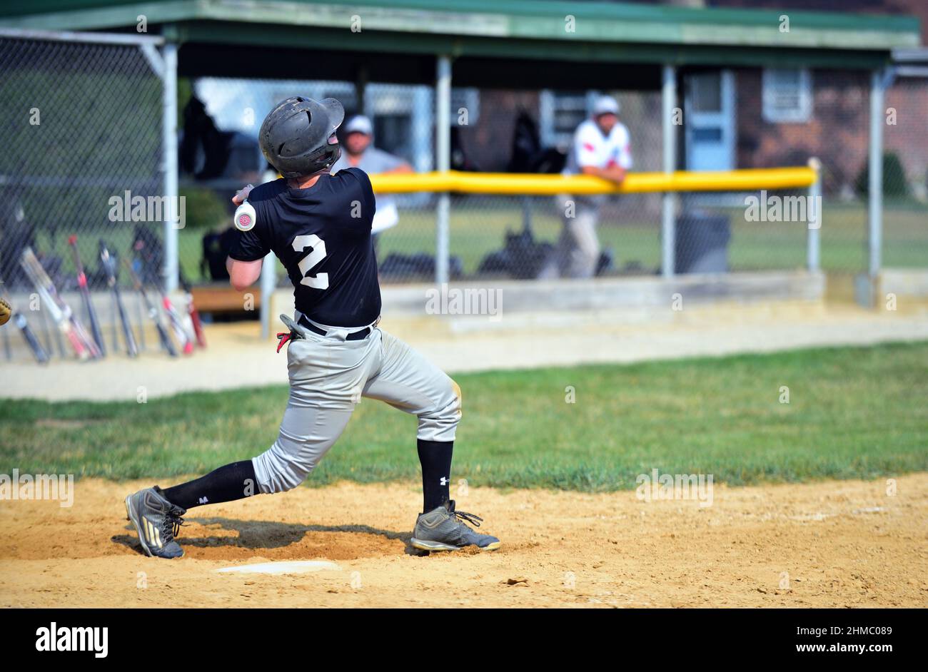 Johnsburg, Illinois, USA. A batter's follow through after swinging at a pitch during a men's amateur baseball game in northeastern Illinois. Stock Photo