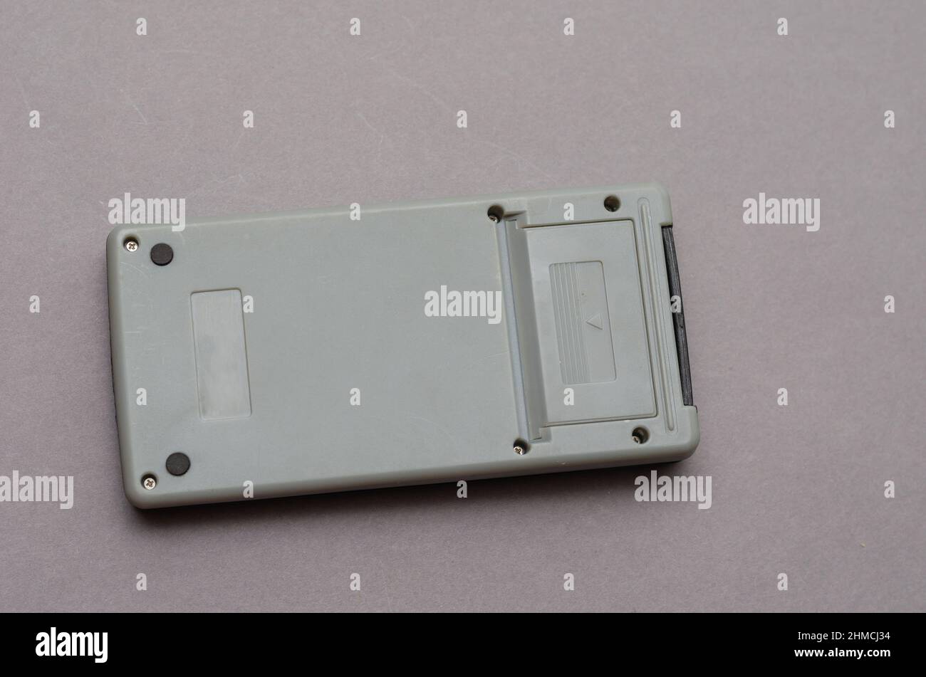 Closed Scientific calculator opposite the gray background. Rectangular