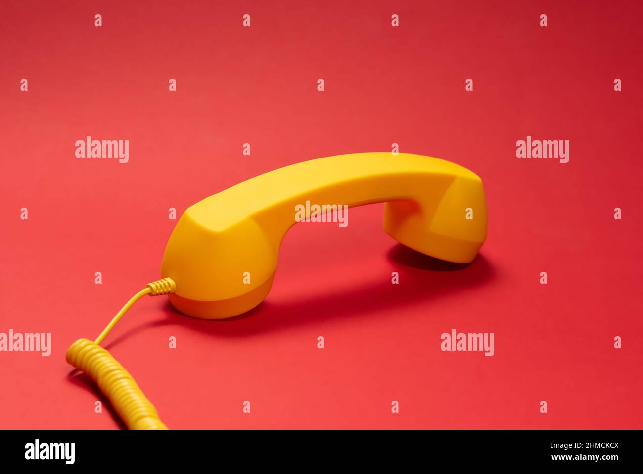 Yellow handset on red background. Copy space Stock Photo Alamy