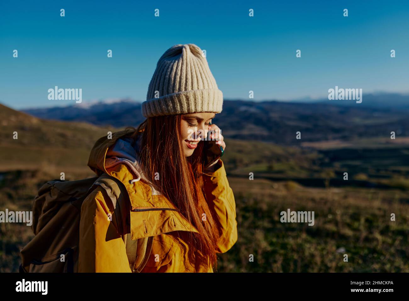 woman tourist in a yellow jacket in a hat backpack travel mountains