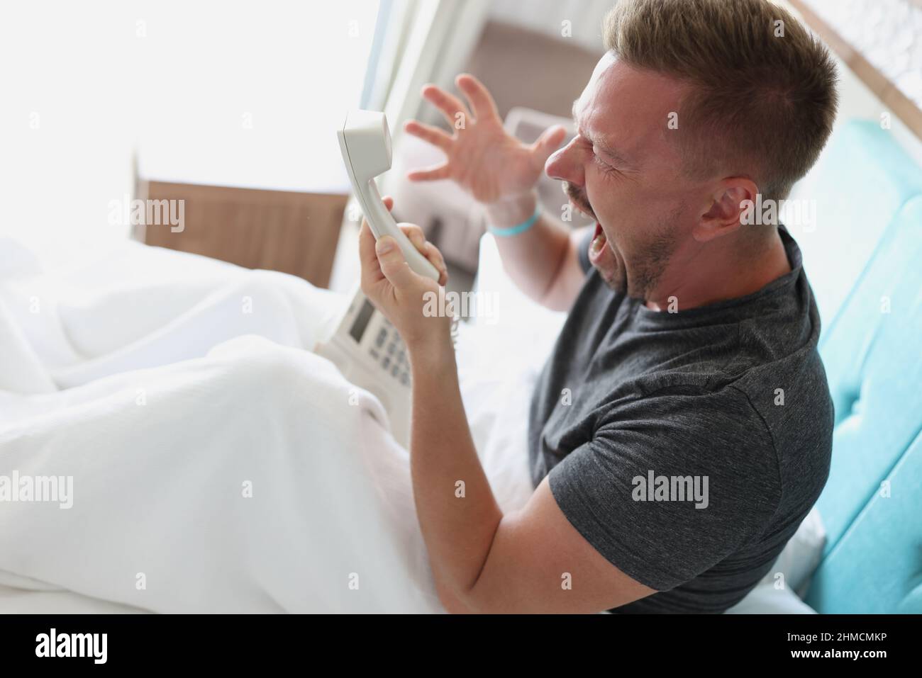 Middle aged man scream on someone over phone, man not satisfied with hotel service Stock Photo