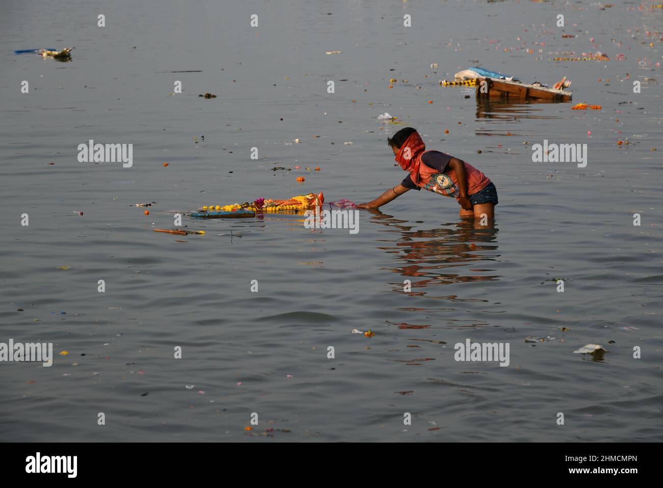 A man floating Hindu goddess Saraswati idol for immersion on the Ganges
