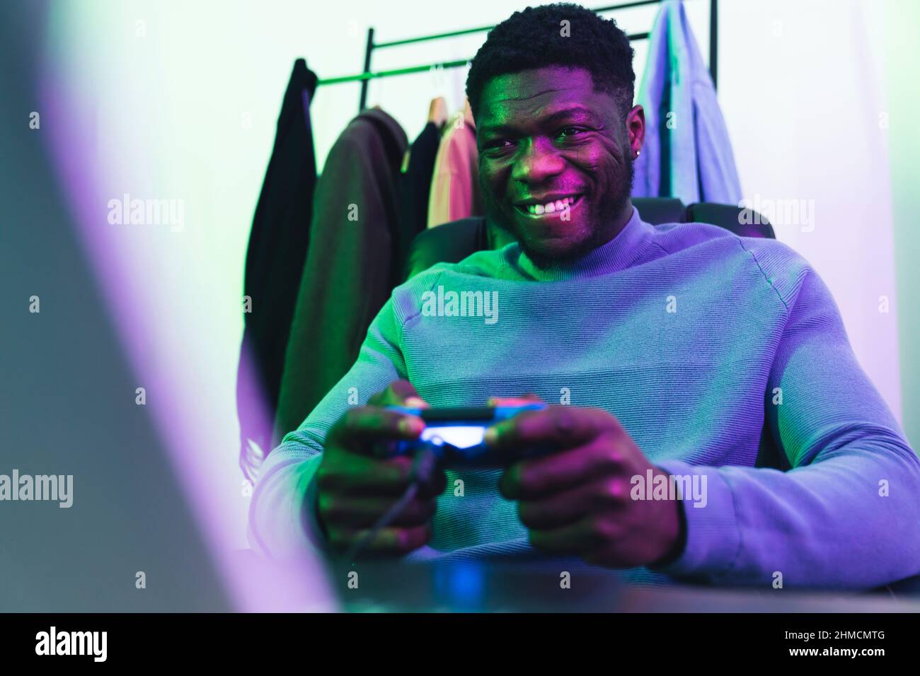 Happy afroamerican man playing computer game pad - medium shot. High quality photo Stock Photo