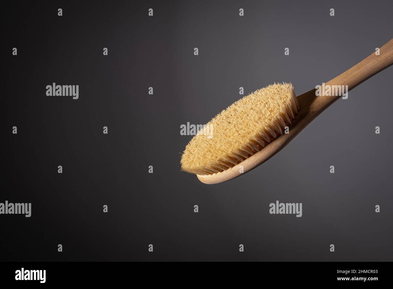 wooden brush for body dry massage anti cellulite peeling body care. on dark background Close-up Stock Photo