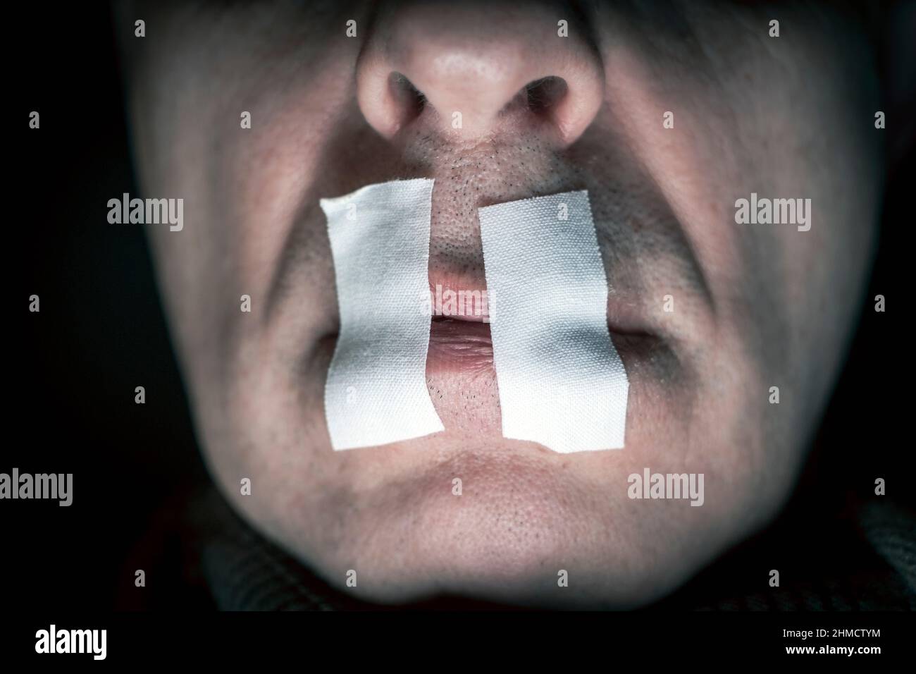 a male face and lips stitched with adhesive tape, studio portrait Stock Photo Alamy