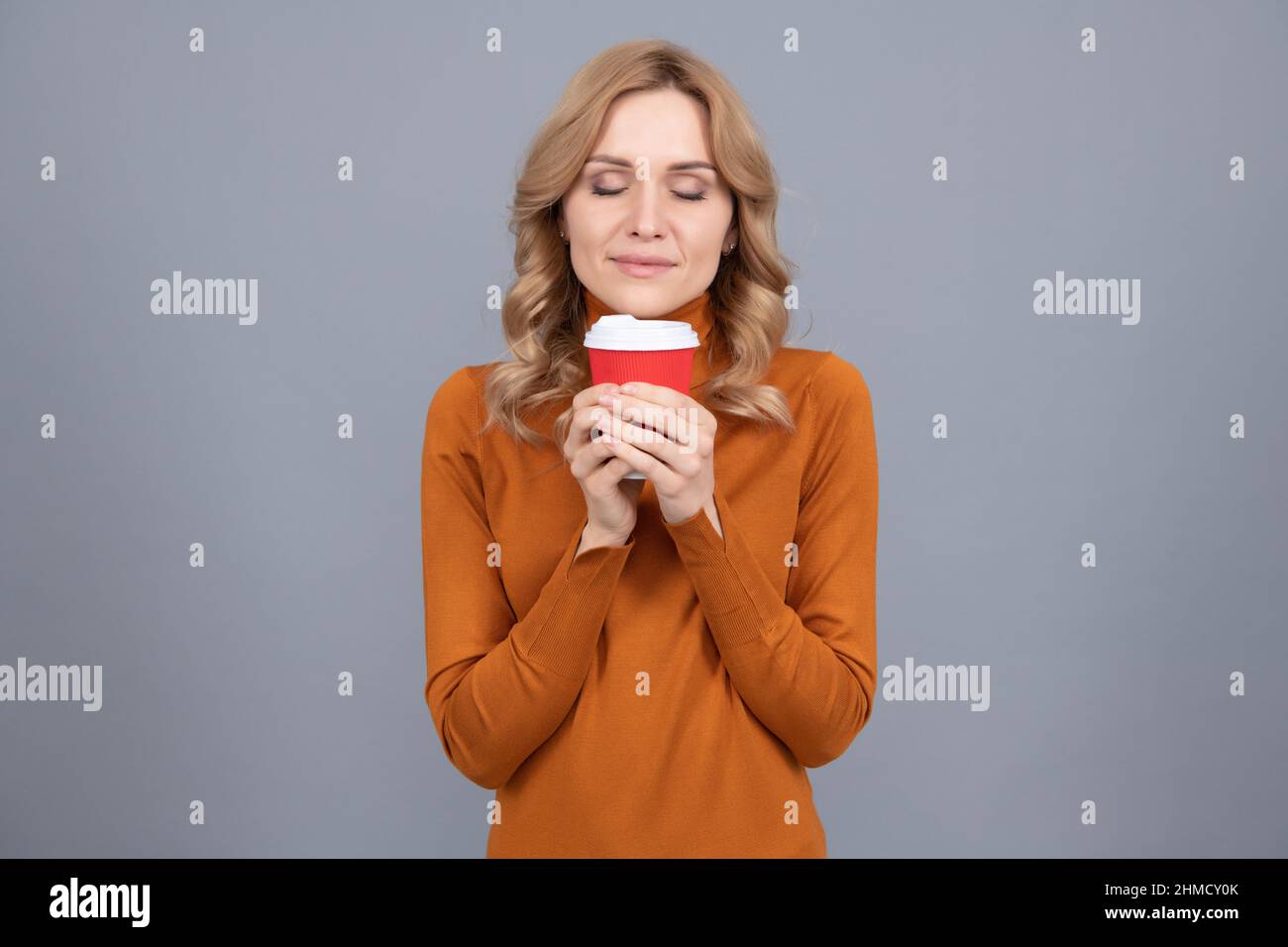 Pretty woman with closed eyes enjoy aroma of fresh brewed tea or coffee, enjoying life Stock Photo