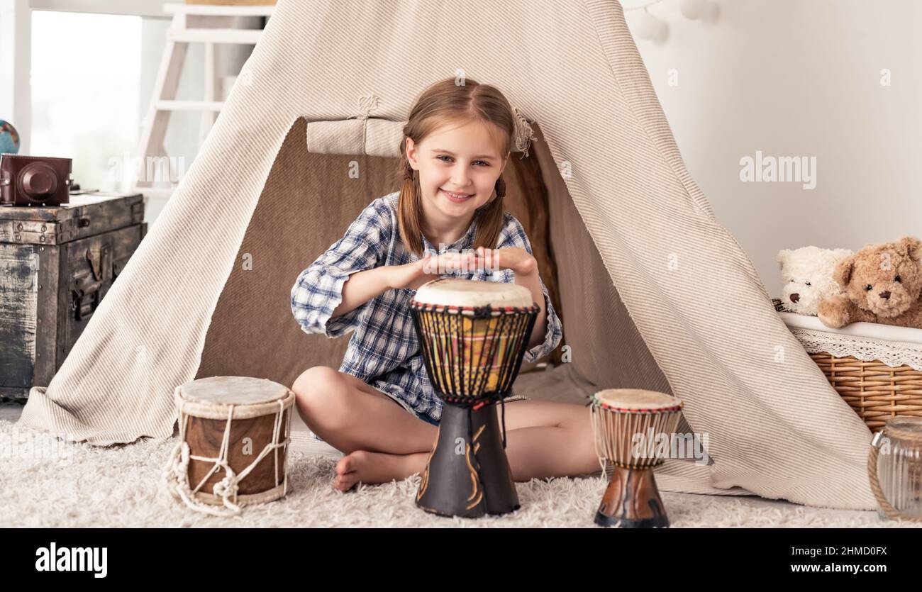 Little girl playing on djembe drums Stock Photo Alamy