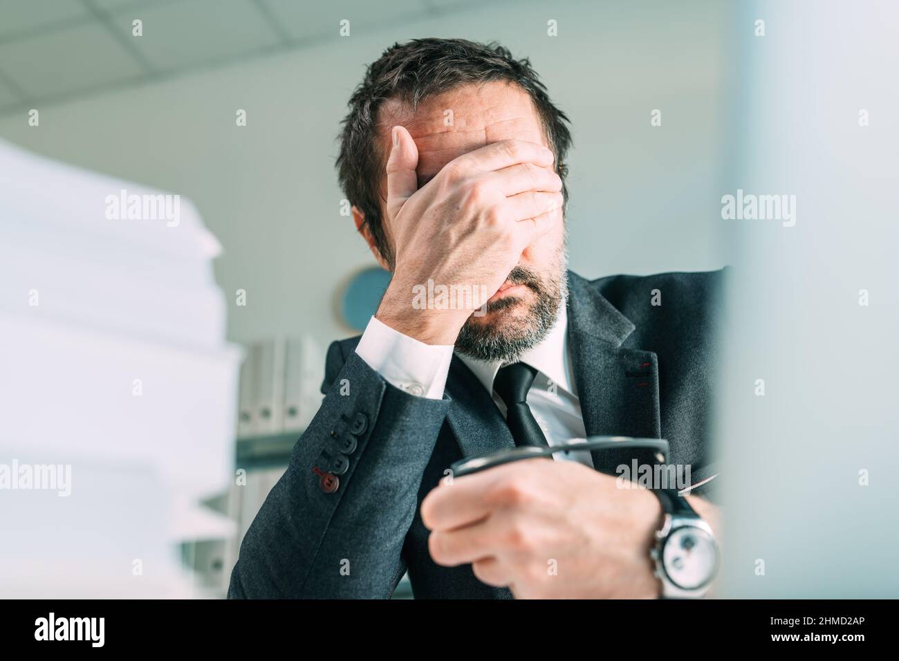Business failure, disappointed businessman entrepreneur covering cafe with hand in disbelief, selective focus Stock Photo