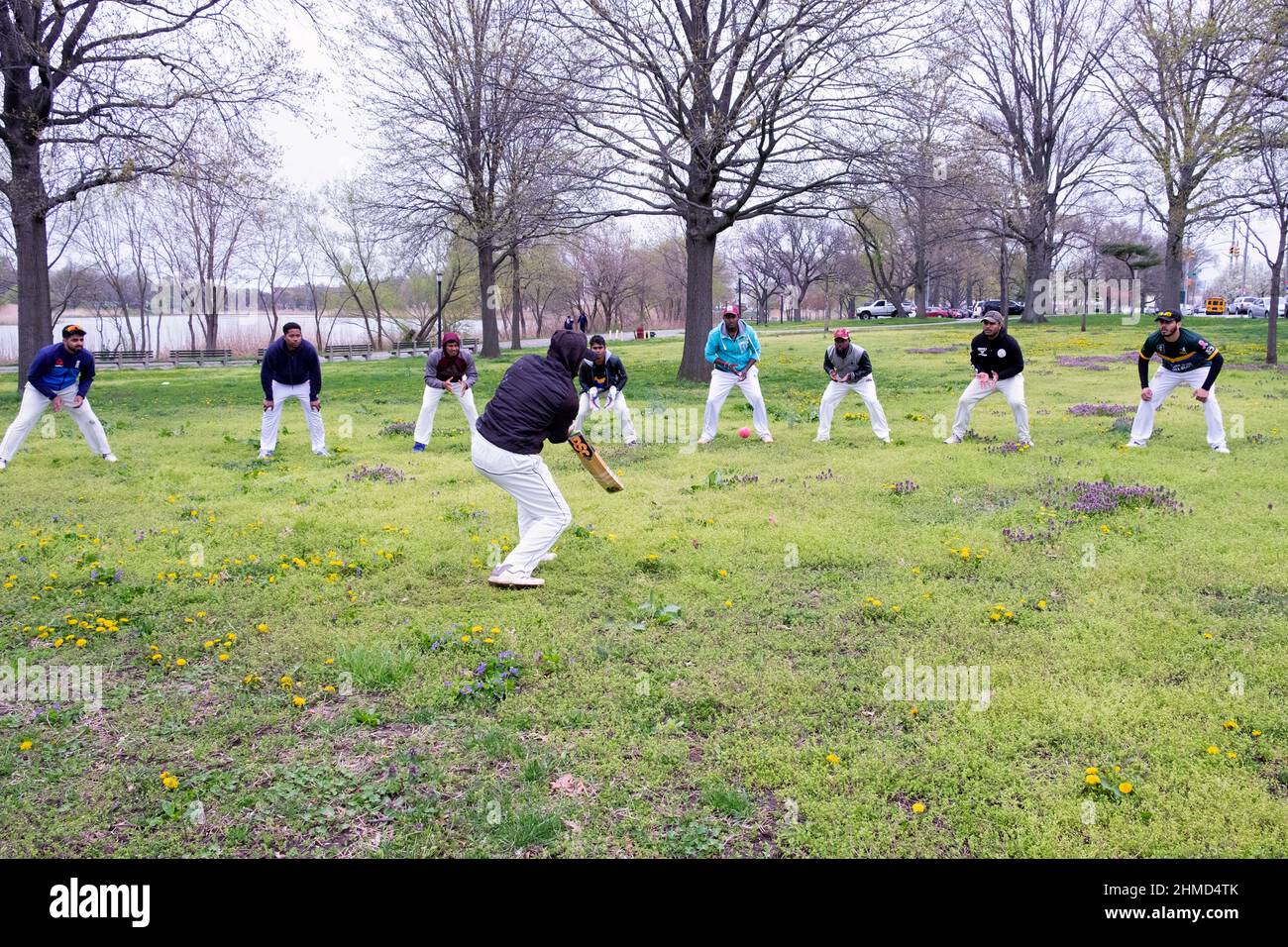 A group of under 25 cricket players warm up by fielding balls in Baisley Pond Park in Jamaica, Queens, New York City. Stock Photo