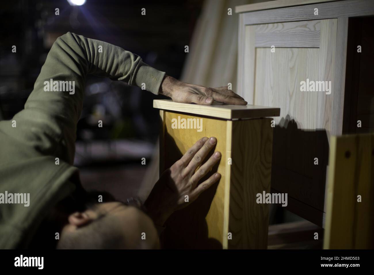 Carpenter makes furniture. Joinery. Man holds closet shelf. Create