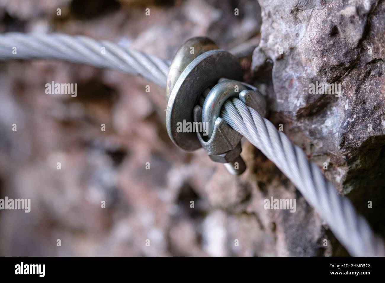 Close - up of a hand rail along a difficult hiking trail in the Franconian Switzerland, Germany, made of steel wire rope with a wire rope clip mounted Stock Photo