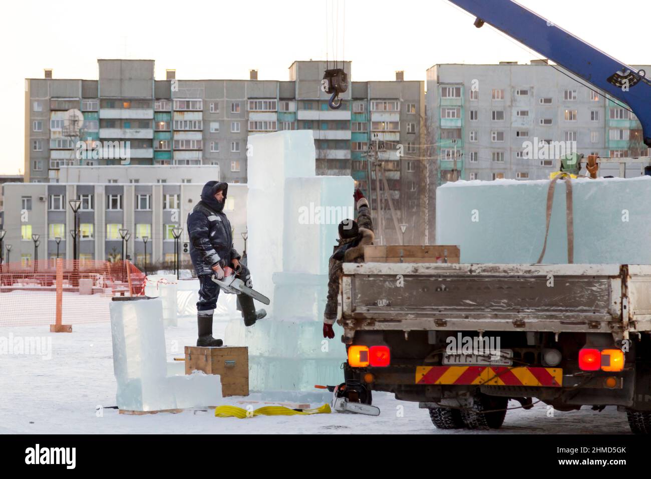 Worker with a chainsaw in hand at the assembly site Stock Photo