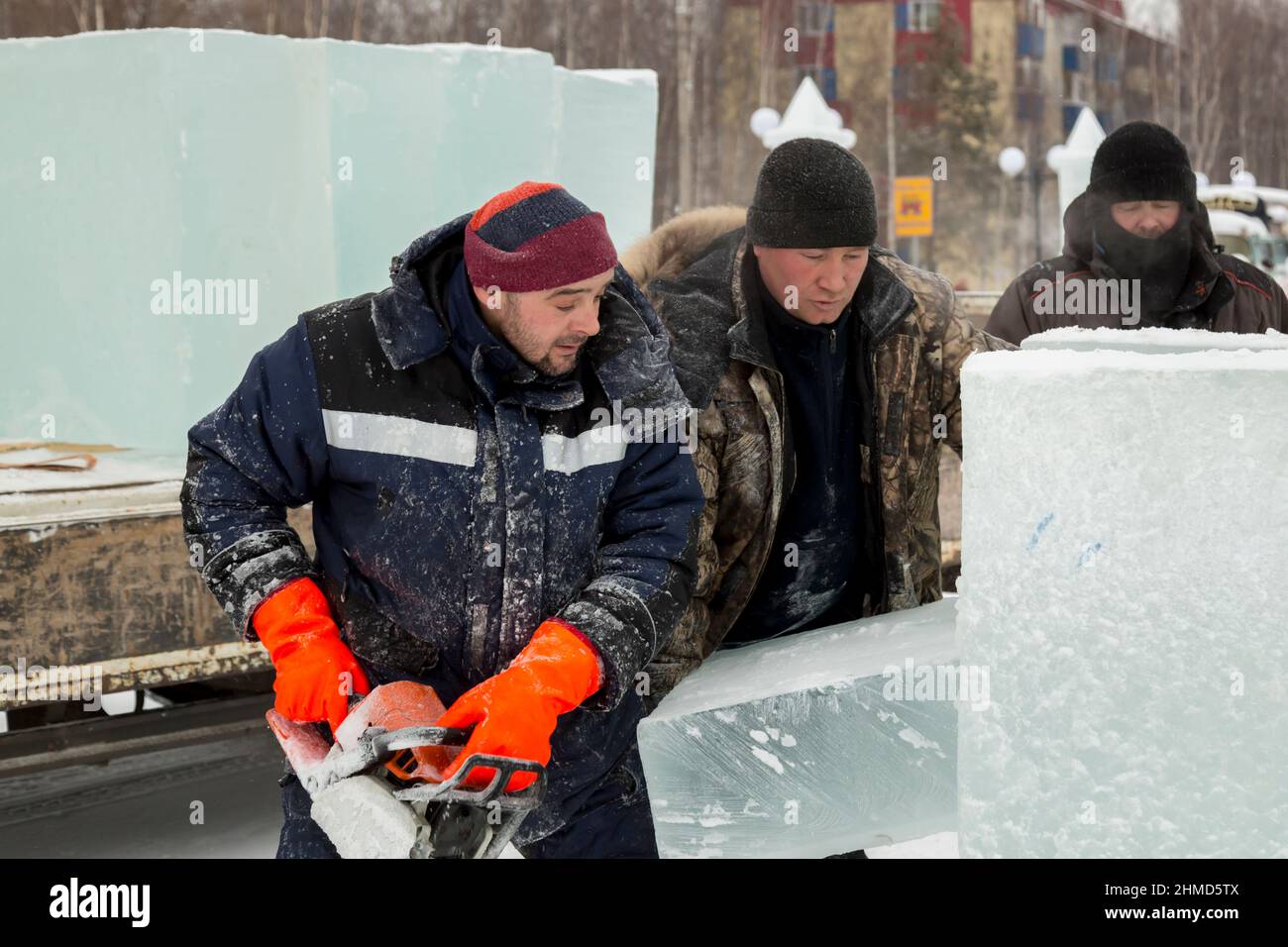 Worker with a chainsaw in hand at the assembly site Stock Photo